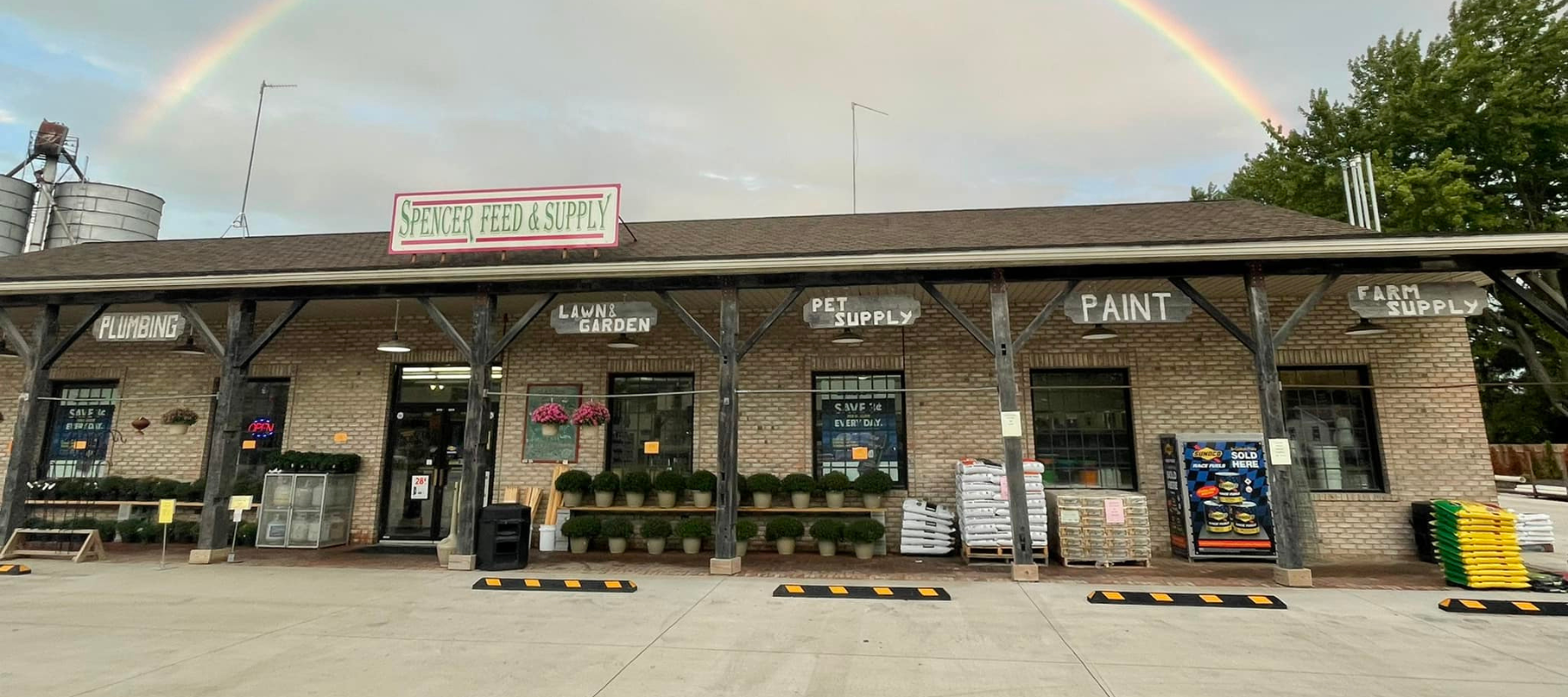Spencer Feed & Supply store front with a rainbow in the background.